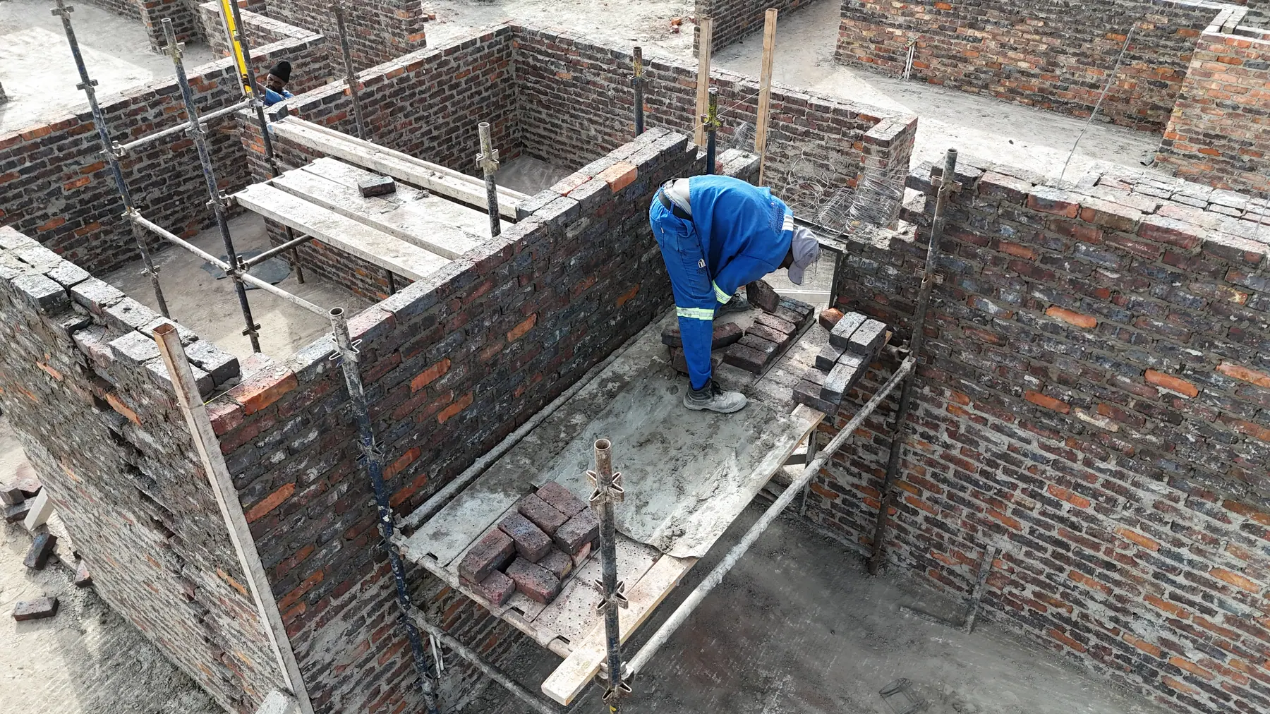 Bricklayers building the superstructure walls on a Ntoampe 0207 Properties site